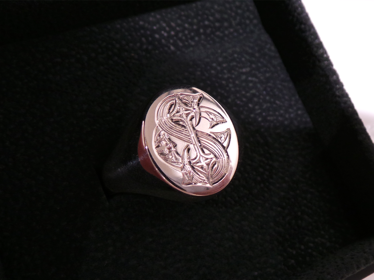Signet ring bearing engraved monogram in black velvet ring box